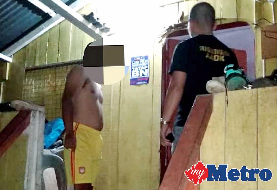 AZMI bersama pegawainya menjalankan pemeriksaan ke atas seorang lelaki disyaki penagih selepas cuba bersembunyi di sebuah bilik di rumahnya di Kampung Empat Murni, Nabawan, Keningau. -Foto IHSAN AADK