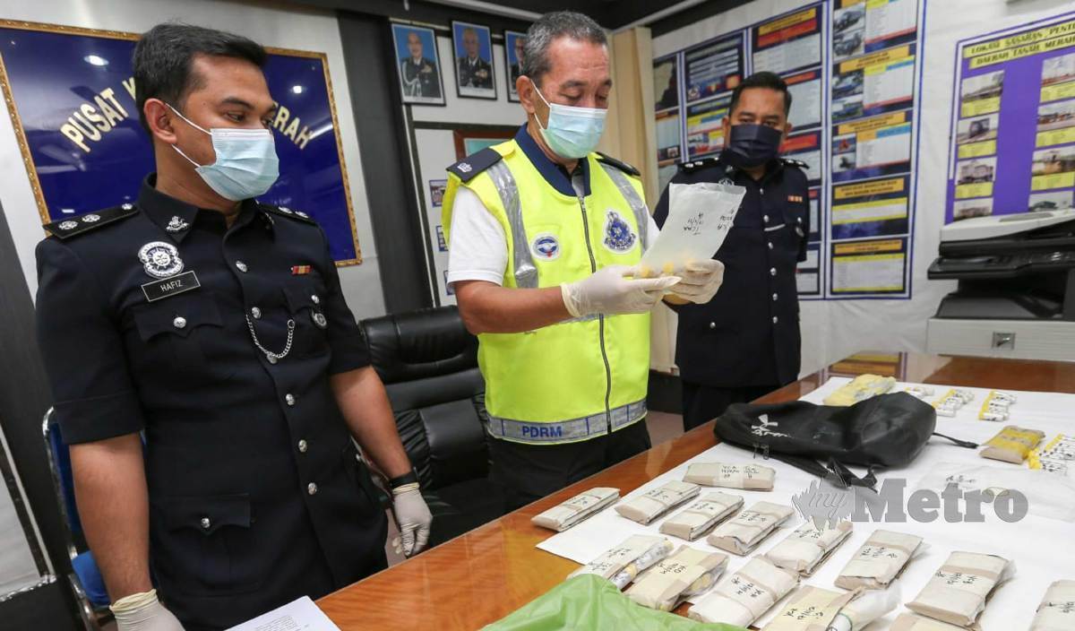 ZAINUDDIN (tengah) menunjukkan rampasan 1.5 kilogram heroin yang dianggarkan bernilai RM380,000 dalam dua serbuan pada sidang media di IPD Tanah Merah. FOTO Nik Abdullah Nik Omar