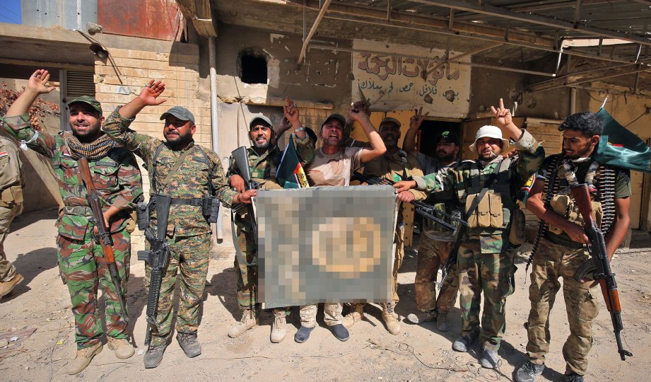ASKAR Iraq menterbalikkan bendera Daish selepas merampas beberapa kawasan penting di Tal Afar daripada kumpulan militan itu. FOTO AFP