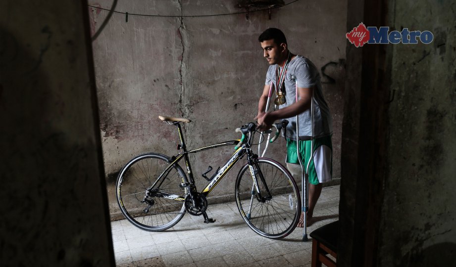 DALY yang kaki kanannya terpaksa dipotong, bersama basikal di rumahnya di Rafah, selatan Gaza. FOTO AFP