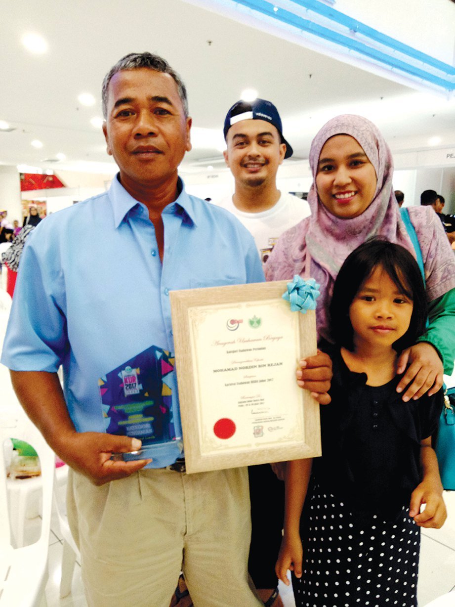 MOHAMAD Nordin (kiri) dan keluarga selepas menerima Anugerah Usahawan Berjaya RISDA kategori usahawan pertanian peringkat negeri Johor 2017.