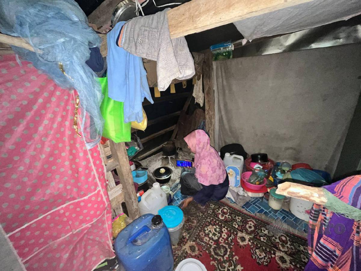Nor Fariza menunjukkan dapur kayu diruang tamu dangau didiami bersama suami dan tiga anaknya sejak hampir setahun lalu di Kampung Pokka. FOTO IZAD THAQIF HASSAN