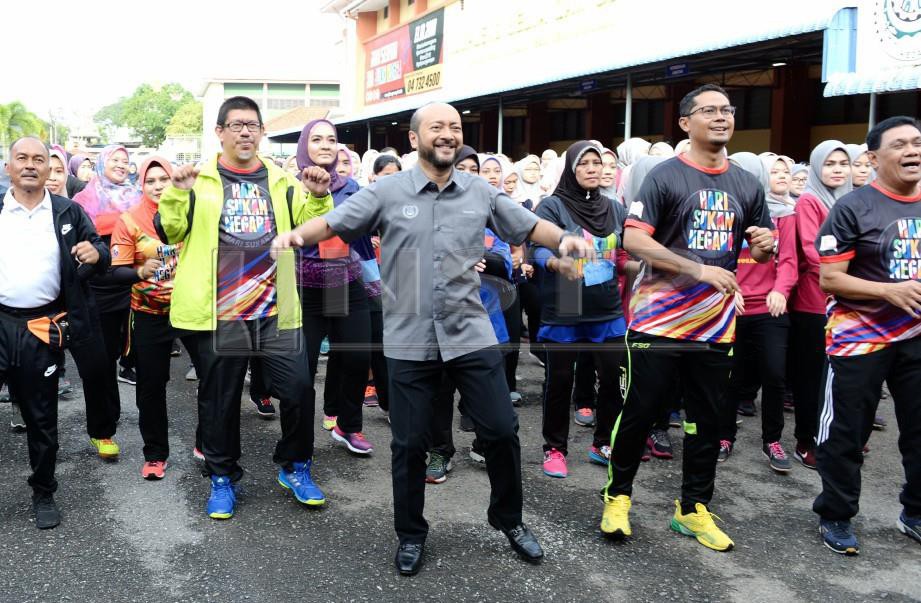 MUKHRIZ (tengah) bersama Asmirul (dua dari kanan) bersenam robik bersama orang ramai pada majlis Hari Sukan Negara, Peringkat Negeri Kedah yang diadakan di Kompleks Belia dan Sukan,Jalan Stadium. -Foto AMRAN HAMID 