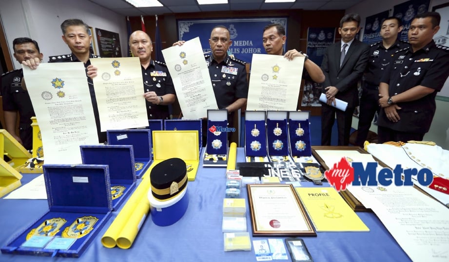 Mohd Khalil (tengah) menunjukkan sijil, pingat dan pelbagai barang rampasan polis Johor yang membongkar sindiket penawaran Darjah Kebesaran Negeri palsu. FOTO Mohd Azren Jamaludin 