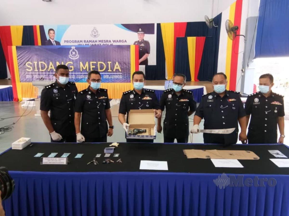 MOHAMAD Farouk (tiga dari kiri) menunjukkan pistol yang dirampas daripada seorang lelaki pada sidang media di IPD Ampang Jaya, hari ini. 