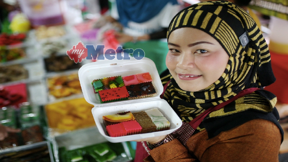 ZARIMA menunjukkan kuih dan puding yang dijual. FOTO Hazreen Mohamad