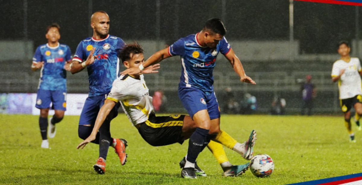 PEMAIN Perak FC mengasak pemain PDRM FC di Stadium MBPJ. FOTO PDRM FC