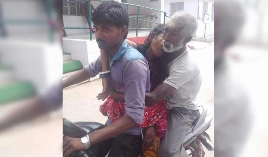 PAPPU membonceng motosikal yang ditunggang Sah sambil memegang mayat isterinya untuk dibawa pulang ke kampung. FOTO HT