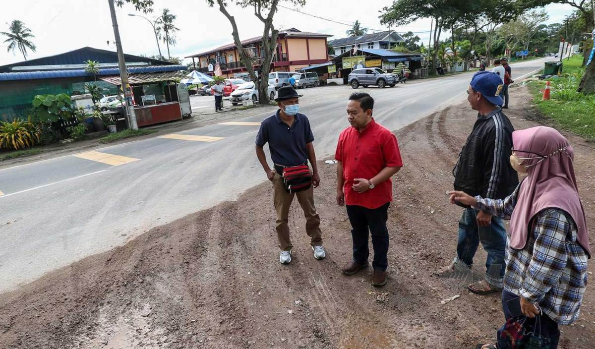 WAN Saiful (dua kiri) mendengar luahan penduduk dan peniaga mengenai masalah pencemaran debu akibat kenderaan berat termasuk lori tanah keluar masuk di Kampung Lubuk Meriam. FOTO Danial Saad