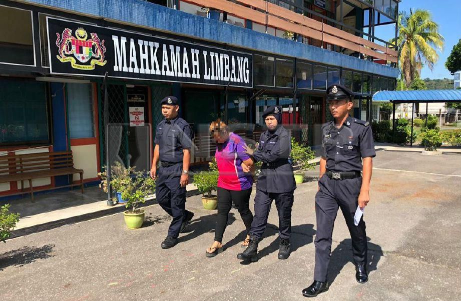 Anggota polis mengiringi suspek kes mendera kanak-kanak dua tahun sembilan bulan untuk tahanan reman di Mahkamah Majistret Limbang, Sarawak. FOTO Ihsan PDRM.