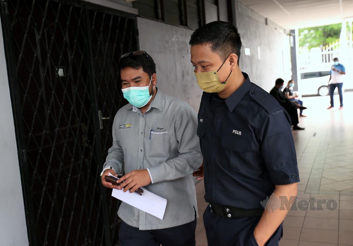 Anggota polis mengiringi wakil  Lumut Maritime Terminal Sdn Bhd di Mahkamah Sesyen Ipoh. FOTO SHARUL HAFIZ ZAM
