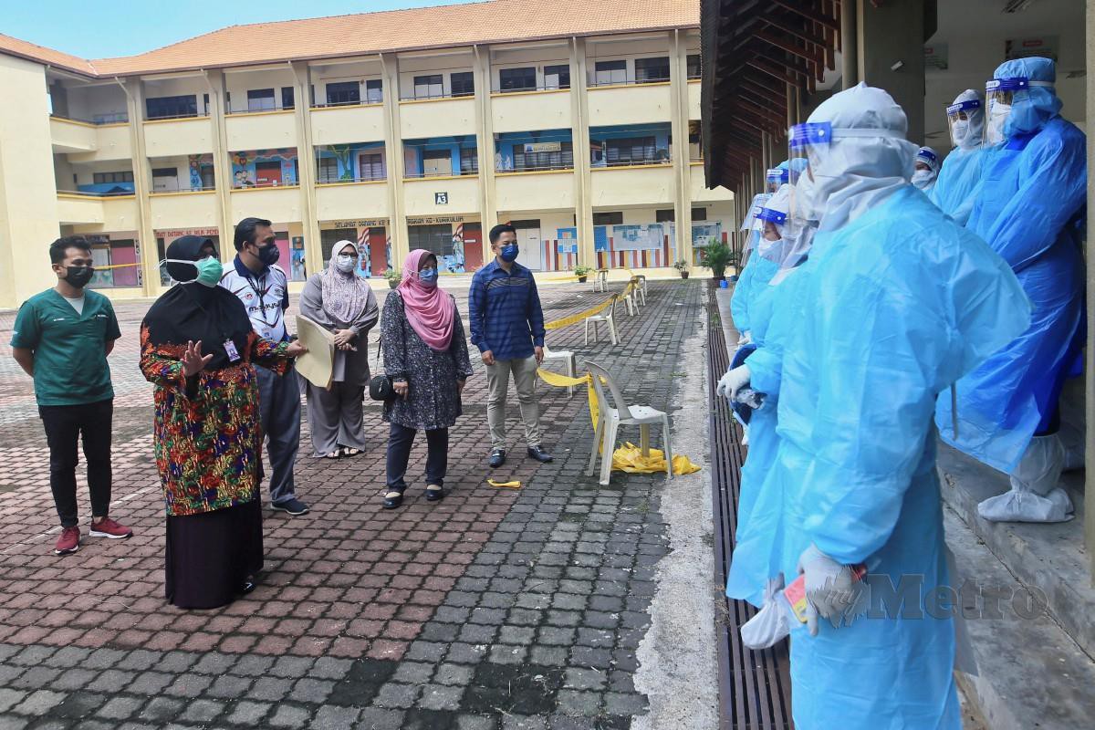 Dr Nor Azimi (kiri) memberi taklimat kepada petugas kesihatan ketika melawat di Sekolah Kebangsaan Gong Pasir. Tiga lokaliti di Mukim Sura, Dungun membabitkan Rumah Awam Kos Rendah Gong Pasir, Kampung Gong Pasir dan Taman MAIDAM. FOTO GHAZALI KORI