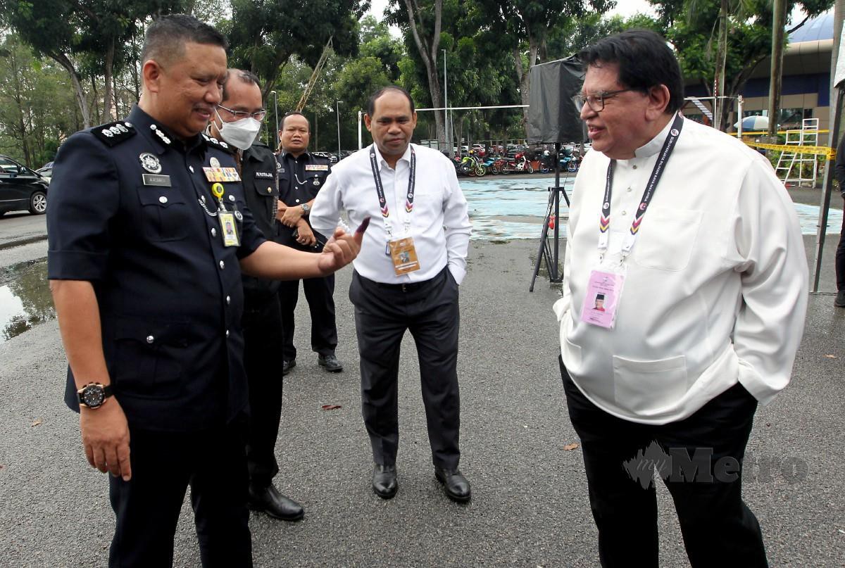 Tengku Adnan berbual bersama Ketua Polis Daerah Putrajaya, ACP A Asmadi Abdul Aziz ketika meninjau proses pengundian awal sempena Pilihan Raya Umum ke-15 (PRU15) di Ibu Pejabat Polis Daerah Putrajaya. FOTO MOHD FADLI HAMZAH