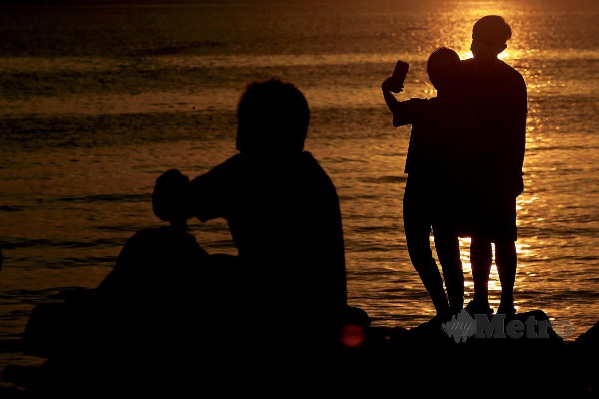 PORT DICKSON, 11 Okt  -- Orang ramai mengambil gambar bersama semasa menikmati suasana indah permai apabila langit membiru dan kekuningan ketika sang suria mula terbenam di perairan pantai Port Dickson hari ini.Menyaksikan panorama matahari terbenam antara pengalaman menarik selain dari menikmati keseronokan bermain aktiviti sukan air ketika mengunjungi destinasi pelancongan di daerah ini. --fotoBERNAMA (2021) HAK CIPTA TERPELIHARA