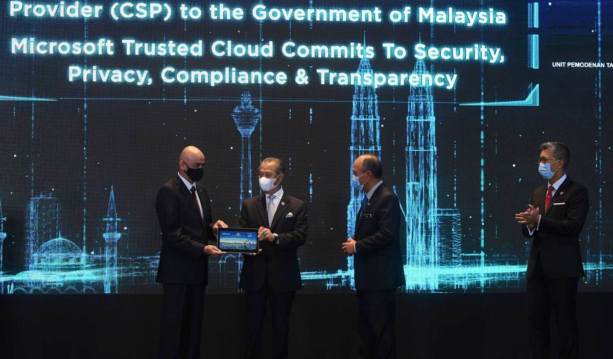 MUHYIDDIN (tiga,kanan) menyerahkan surat pelantikan Microsoft selaku penyedia perkhidmatan awam untuk Kerajaan Malaysia kepada Pengarah Urusan Microsoft Malaysia K. Raman (kiri) pada Pelancaran Microsoft Bersama Malaysia Global Event hari ini. FOTO BERNAMA