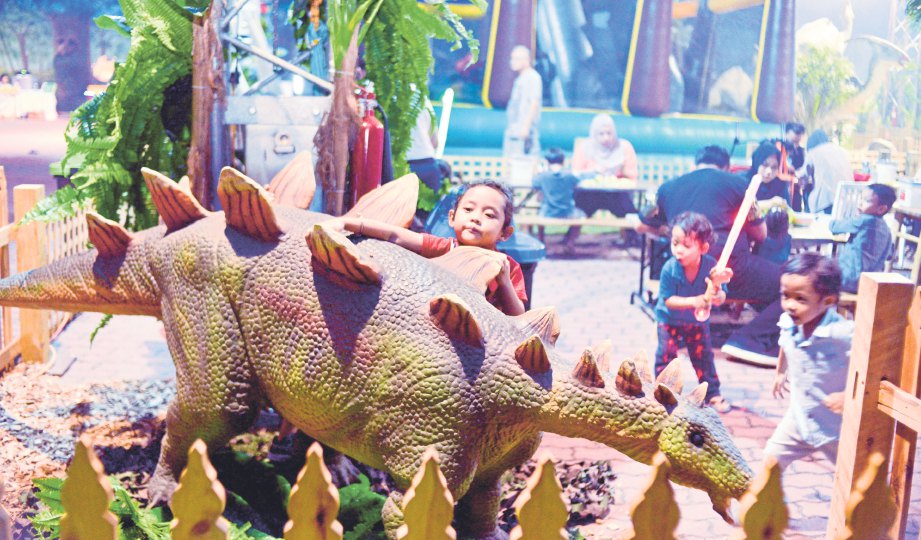 AKSI bersahaja pengunjung cilik memegang dinosaur yang dipamerkan.