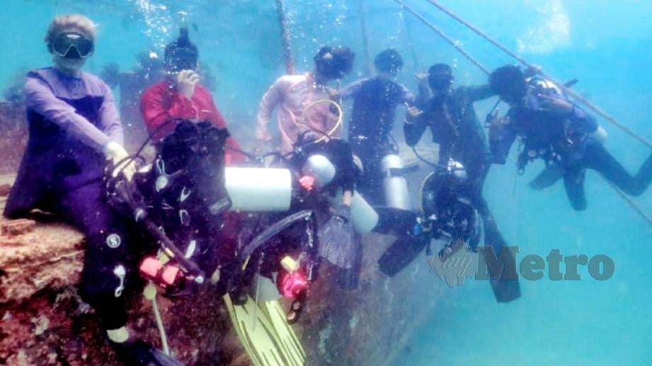 Penyelam menyelam bersama baju Melayu dan baju kurung. FOTO Ihsan Persatuan Penyelam Profesional Semporna 