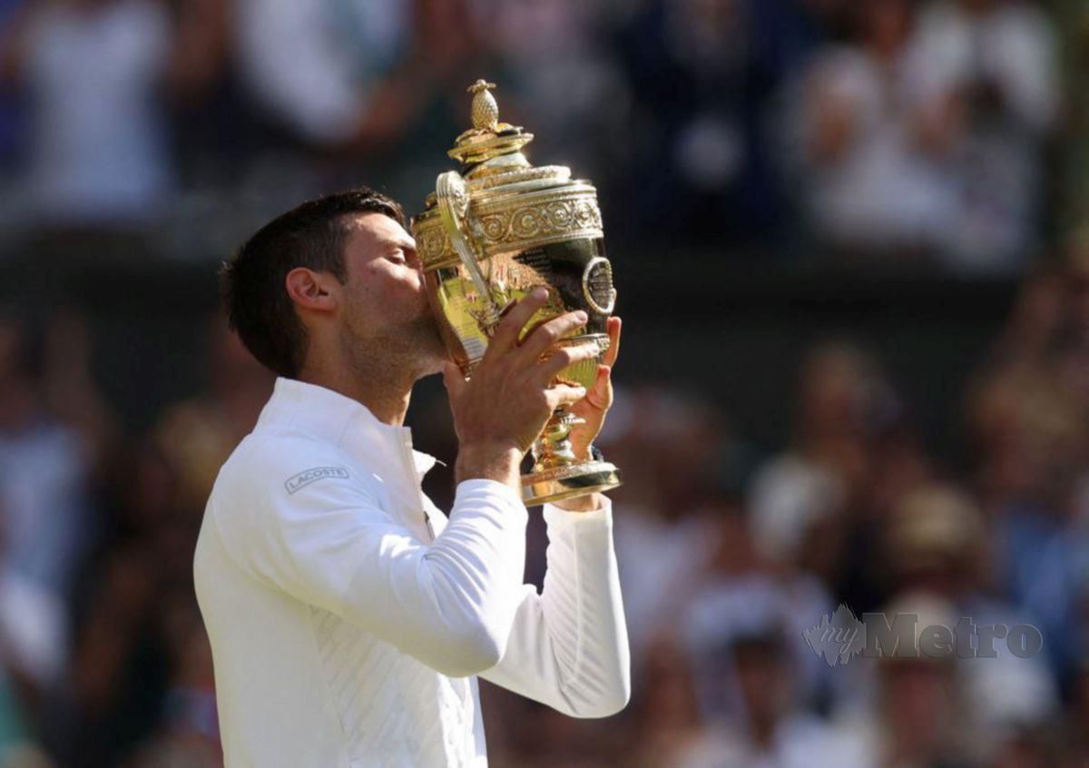PEMAIN Serbia, Novak Djokovic mengucup trofi Wimbledon selepas menewaskan pemain Australia, Nick Kyrgios pada 10 Julai lalu. FOTO REUTERS 