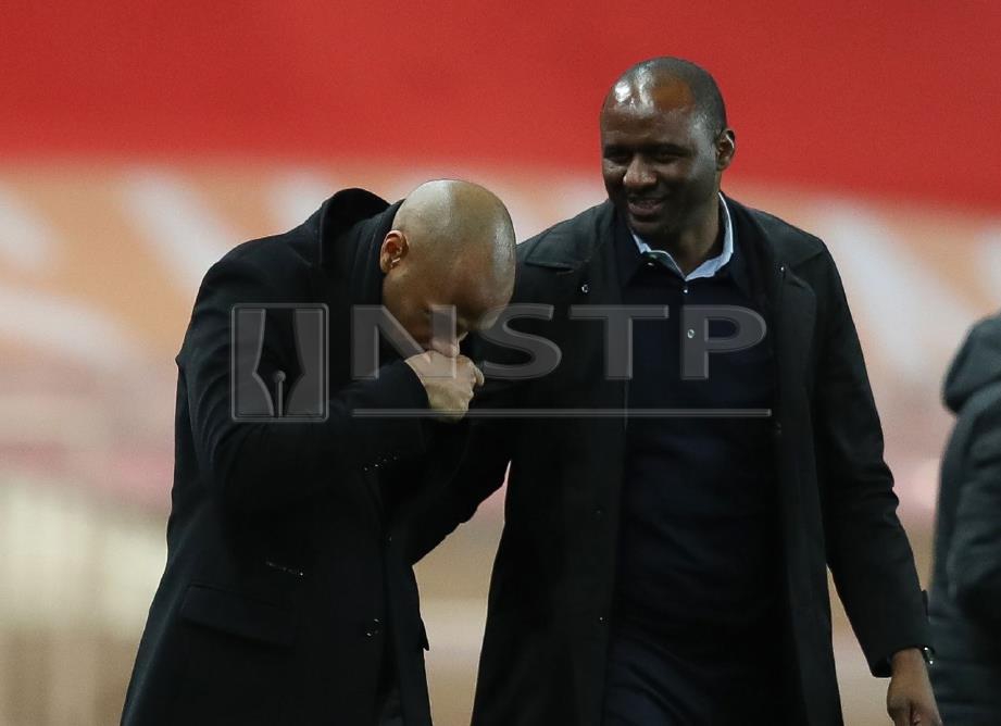 HENRY (kiri) berkata sesuatu kepada Vieira. FOTO/AFP