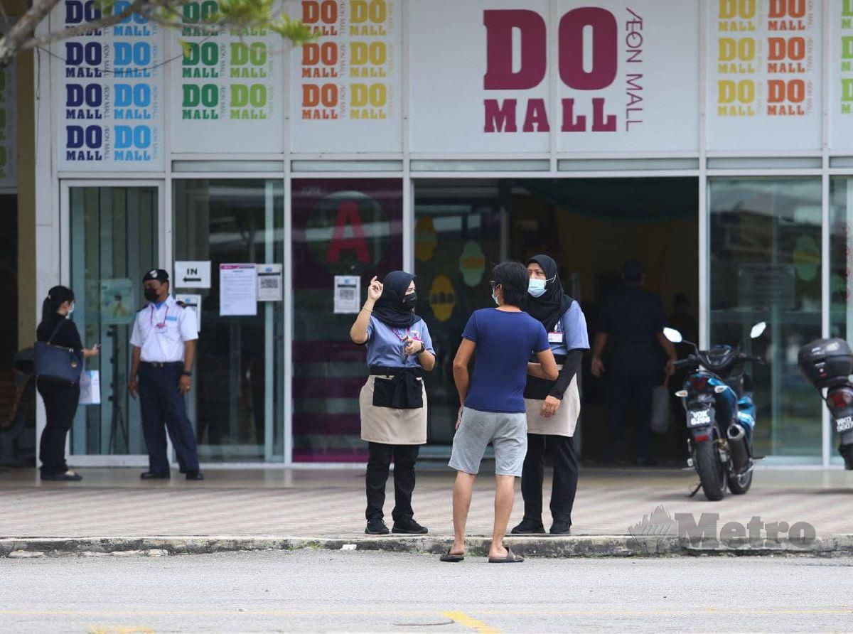 KAKITANGAN AEON memberitahu pelanggan secara bersemuka mengenai penutupan sementara pusat membeli-belah AEON cawangan Bandaraya Melaka selama tiga hari. FOTO Syafeeq Ahmad