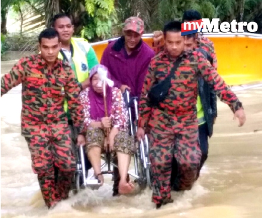 Anggota Jabatan Bomba dan Penyelamat Raub memindahkan mangsa banjir di Kampung  Gali Tengah. - foto Ihsan Bomba