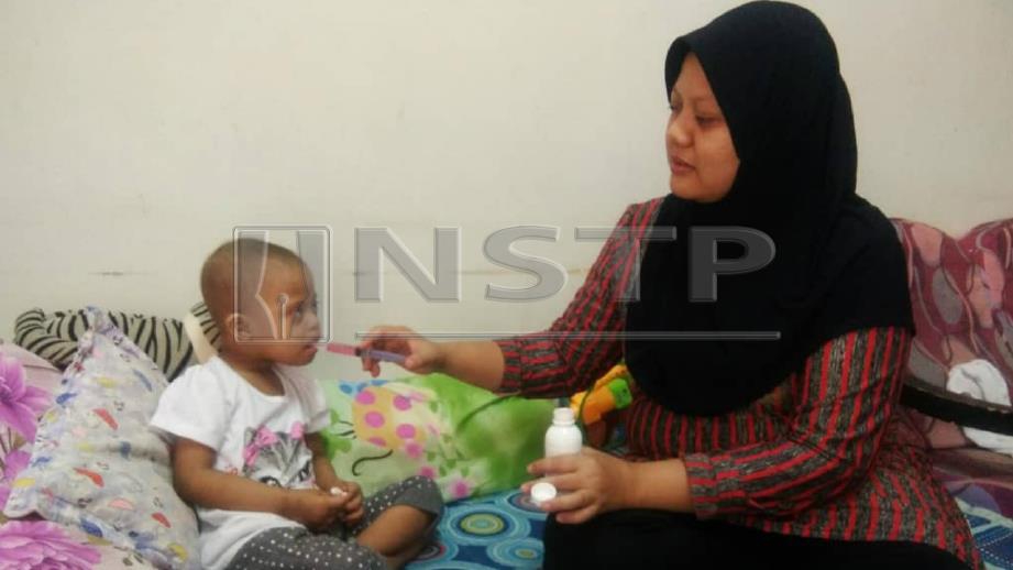 Rozita (kir) memberi ubat kepada Nur Syakila yang menghidap AML. FOTO Nor Farhani Che Ad