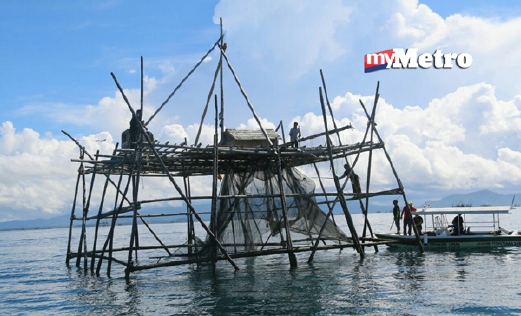 Bagang yang dibina secara haram atau menyalahi syarat  lesen di perairan Kalumpang, Sabah, dirobohkan ketika operasi hari ini. - Foto ESSCOM