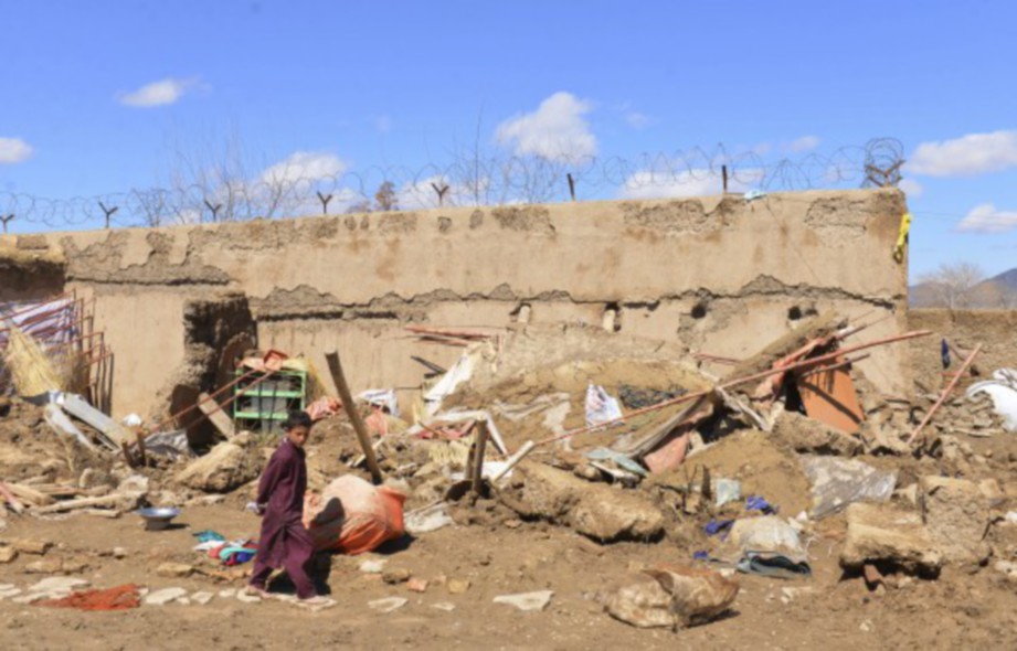KANAK-kanak di depan rumah yang musnah akibat hujan lebat. FOTO/AGENSI