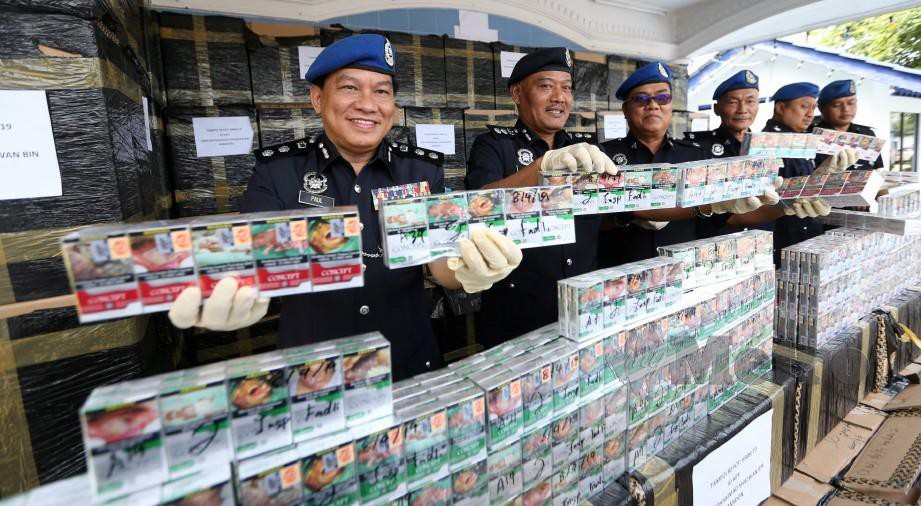  KOMANDER PPM Wilayah 2, Asisten Komisioner Paul Khiu Khon Chiang (kiri) menunjukkan 102,500  rokok pelbagai jenama dirampas dalam serbuan di Kawasan Perindustrian Taman Johor.