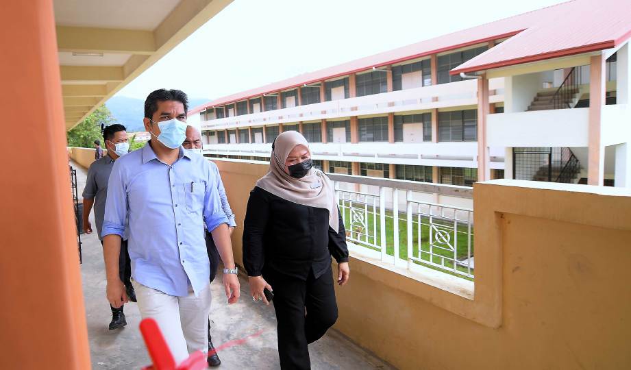 DR Radzi (kiri) melawat kawasan blok asrama yang telah dibaik pulih dan boleh digunakan semula pada lawatan kerja siri ke-3 di SMK Bandaraya, Kota Kinabalu. FOTO BERNAMA