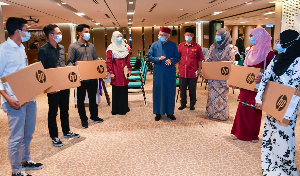 DR Zulkifli  (tengah) beramah mesra bersama pelajar asnaf Universiti Teknologi Malaysia (UTM) yang menerima sumbangan komputer riba pada majlis penyerahan sumbangan itu di Menara Tabung Haji . FOTO BERNAMA
