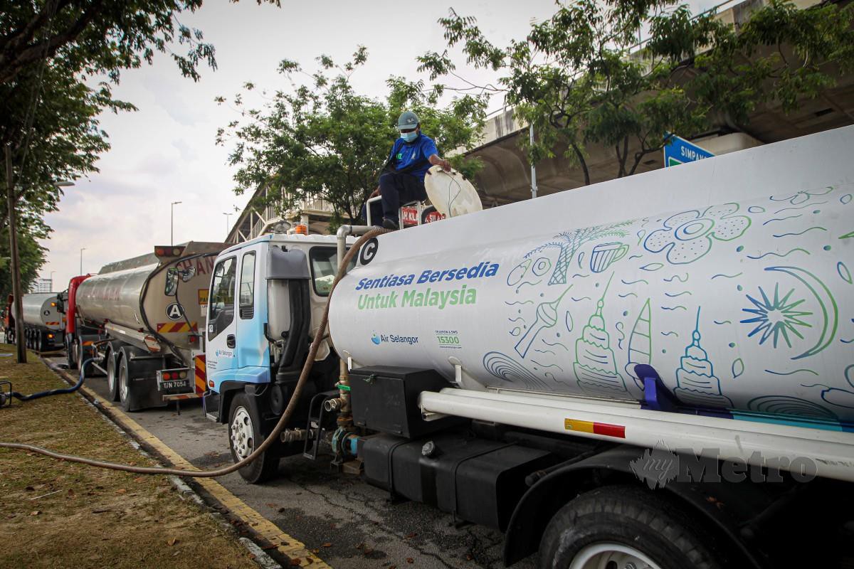 PETUGAS Air Selangor memindahkan air daripada Tanker Jumbo ke Tanker Air Selangor sebelum diagihkan kepada kawasan yang terjejas di hadapan Kompleks 3K, Subang Jaya. FOTO AZIAH AZMEE