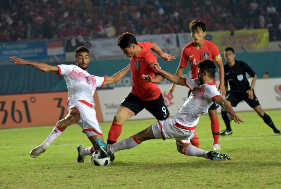 PEMAIN Korea Selatan Hwang Hee-chan (tengah) cuba melepasi kawalan pemain Bahrain Husain Alkhayyat (kiri) dan Mohammed Sayed Shubbar. -Foto AFP