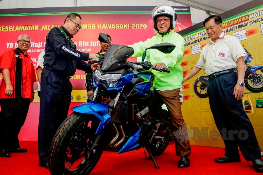 KAMARUDDIN menaiki motosikal Kawasaki Z250 sambil disaksikan Pengerusi Persatuan Pengedar Motorsikal & Skuter Malaysia (MMSDA), Wee Hong (kanan), Pengurus Besar dan Pengarah Kawasaki Motors (Malaysia) Sdn Bhd, Datuk Jeffrey Lim ketika melancarkan Kempen Keselamatan Jalan Raya Kawasaki 2020. FOTO AIZUDDIN SAAD