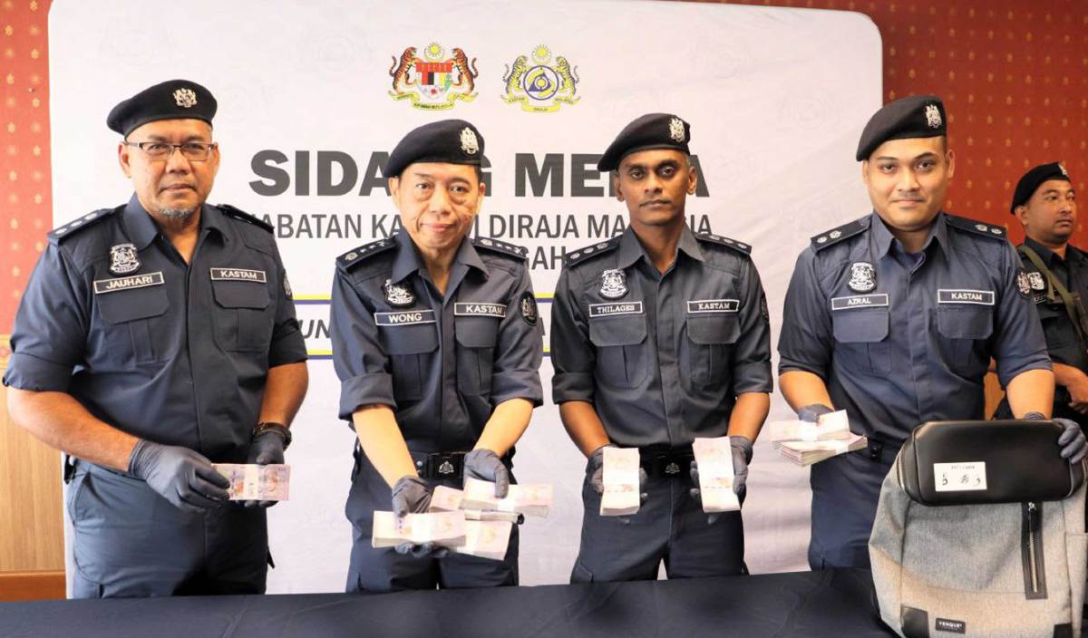 POH Sian (dua kiri) menunjukkan matawang Malaysia yang berjaya dirampas untuk diseludup keluar oleh warga China ke Thailand. FOTO Ihsan JKDM