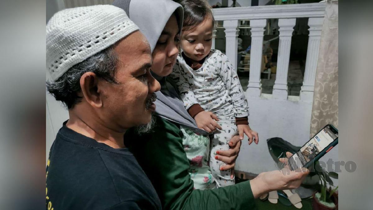 FAUZIAH dan suaminya, Masri Mohd Kasri, 51, membaca berita kemalangan maut membabitkan Nur Aimi dan tiga anaknya. FOTO Asyraf Hamzah