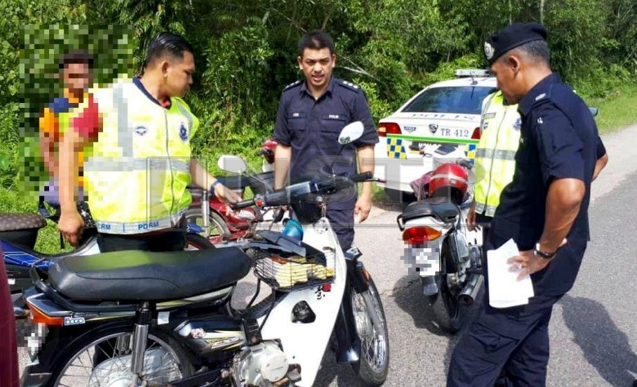 POLIS memeriksa sebuah motosikal dalam operasi itu.  FOTO Rosli Ilham