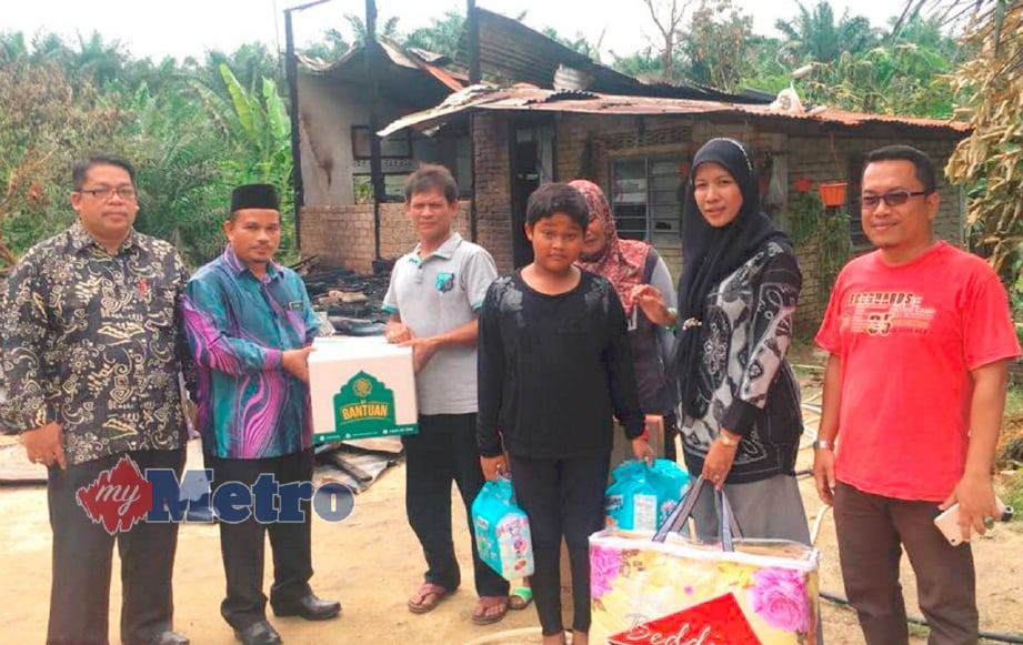 Nursabrina (dua dari kanan) menyampaikan sumbangan kepada mangsa kebakaran di hadapan rumah mereka di Kampung Kuala Dingin, Selama Kedah, Bandar Baharu, hari ini. FOTO ihsan ADUN. 