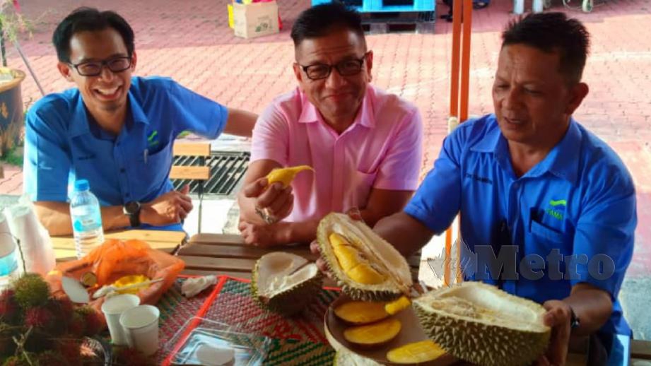 NORHIZAM (tengah) bersama Che Samudin (kanan) merasai durian sempena Melaka Durian Street 2019. FOTO IHSAN PEMBACA