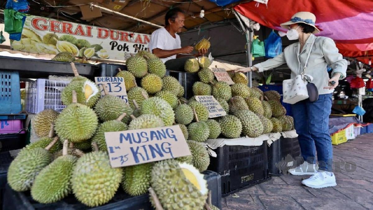 TINJAUAN peniaga yang menjual durian musang king di Pasar Payang. FOTO GHAZALI KORI