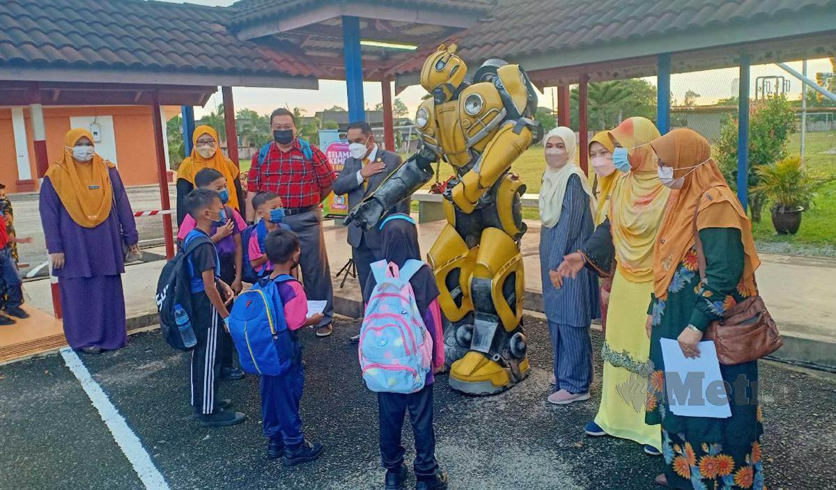 GURU bersama maskot Bumblebee menyambut kehadiran murid-murid di SK Duyong ketika hari pertama sesi persekolahan 2022/2023 hari ini. FOTO Malik Muhamad