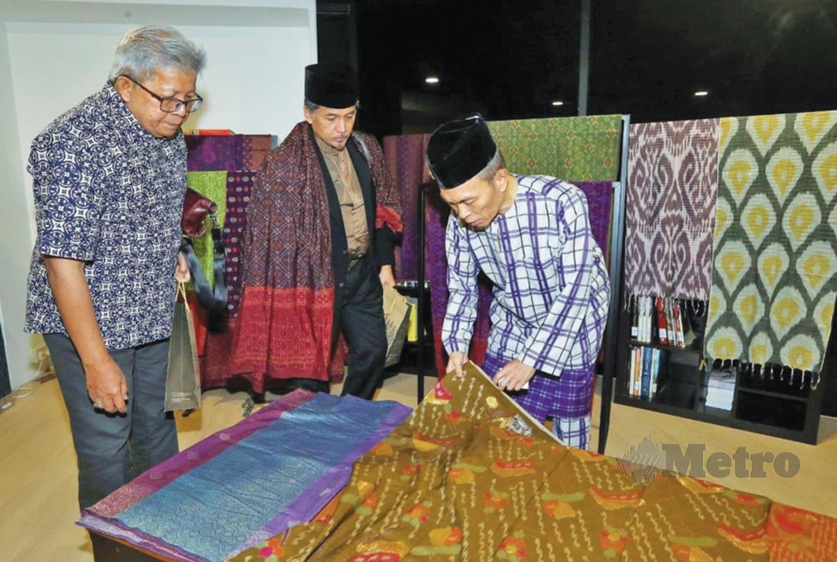 WAN Manang (kiri) dan Shah Reza melihat koleksi songket Ang. 