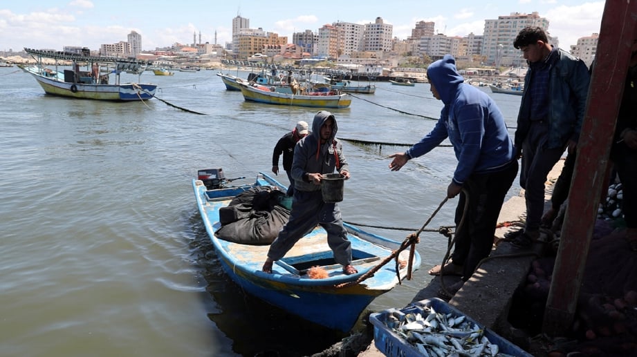 PENDUDUK Palestin mengangkat hasil laut ke jeti.