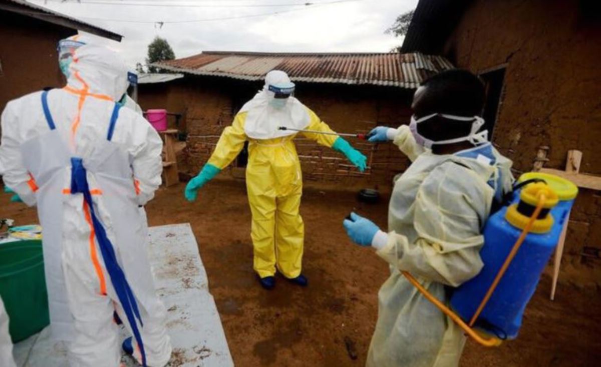PETUGAS kesihatan membantu mendekontaminasikan rakannya sebagai langkah pencegahan Ebola di Congo. FOTO Reuters