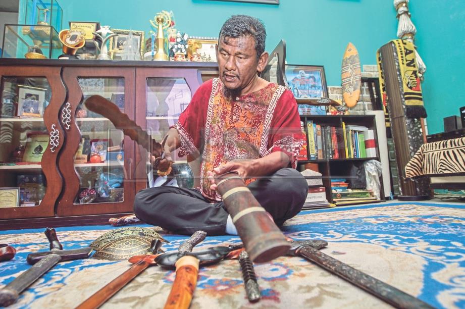 Ebby Yus menunjukkan koleksi keris dan pedang yang dikumpulnya ketika sesi temu bual di Kampung Baru. FOTO Aswadi Alias.