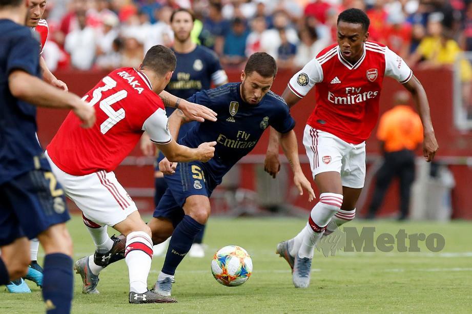 HAZARD (dua kanan) melepasi kawalan pemain tengah Arsenal, Granit Xhaka (dua kiri) pada aksi Piala Juara Antarabangsa. — FOTO Reuters
