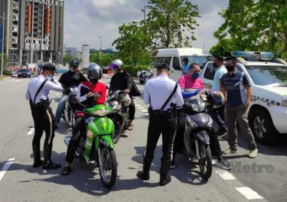 ANGGOTA polis menjalankan pemeriksaan terhadap penunggang motosikal  melalui Op Khas Pemandu E-Hailing Bersepadu. FOTO ihsan polis
