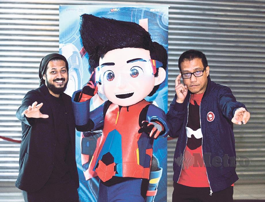 AHMAD Izham (kanan) dan Usamah bergambar bersama poster Ejen Ali pada tontonan teaser filem itu.