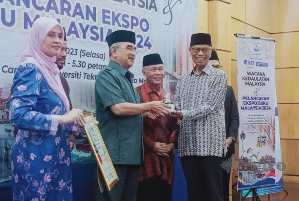 MOHD Ali menyampaikan sijil penghargaan kepada rakan strategik Ekspo Buku Malaysia 2024 di UTeM, sambil diperhatikan Massila (kiri). FOTO Amir Mamat