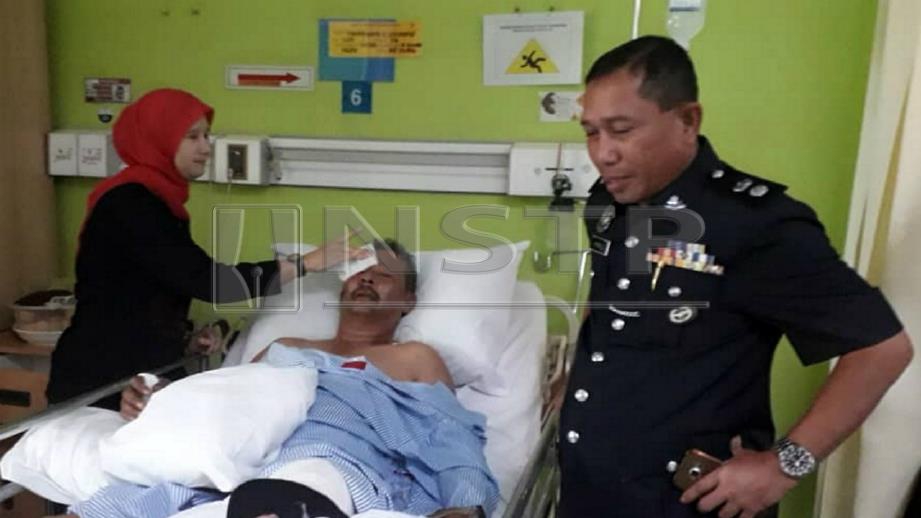 WAN Kamarul Azran (kanan) menziarahi Zaharuddin yang dirawat di Hospital Slim River. FOTO Ihsan PDRM